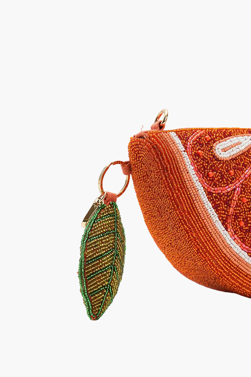 Textured orange coin purse with a leaf charm on a white background
