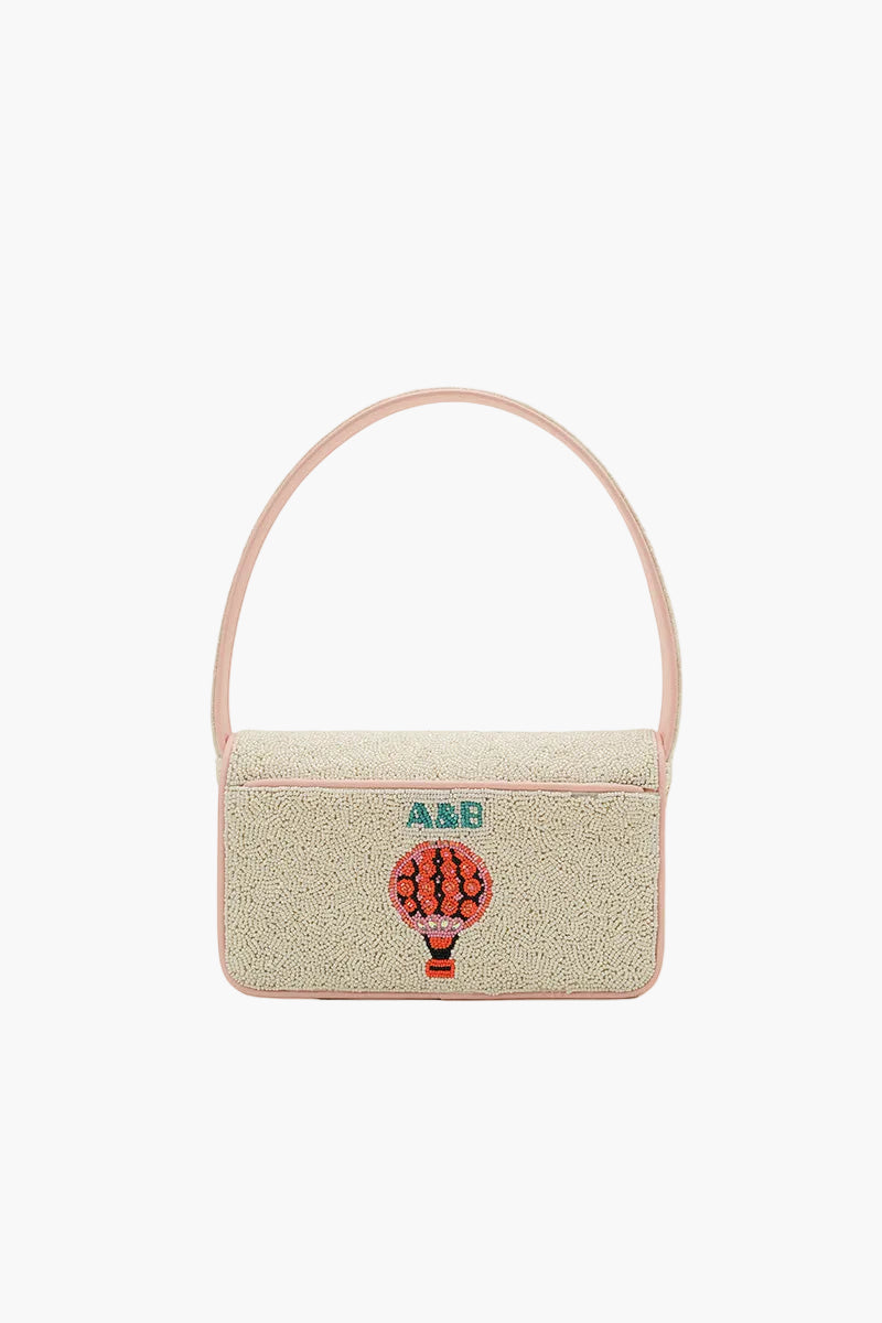 Beige handbag with a hot air balloon design and initials on a white background