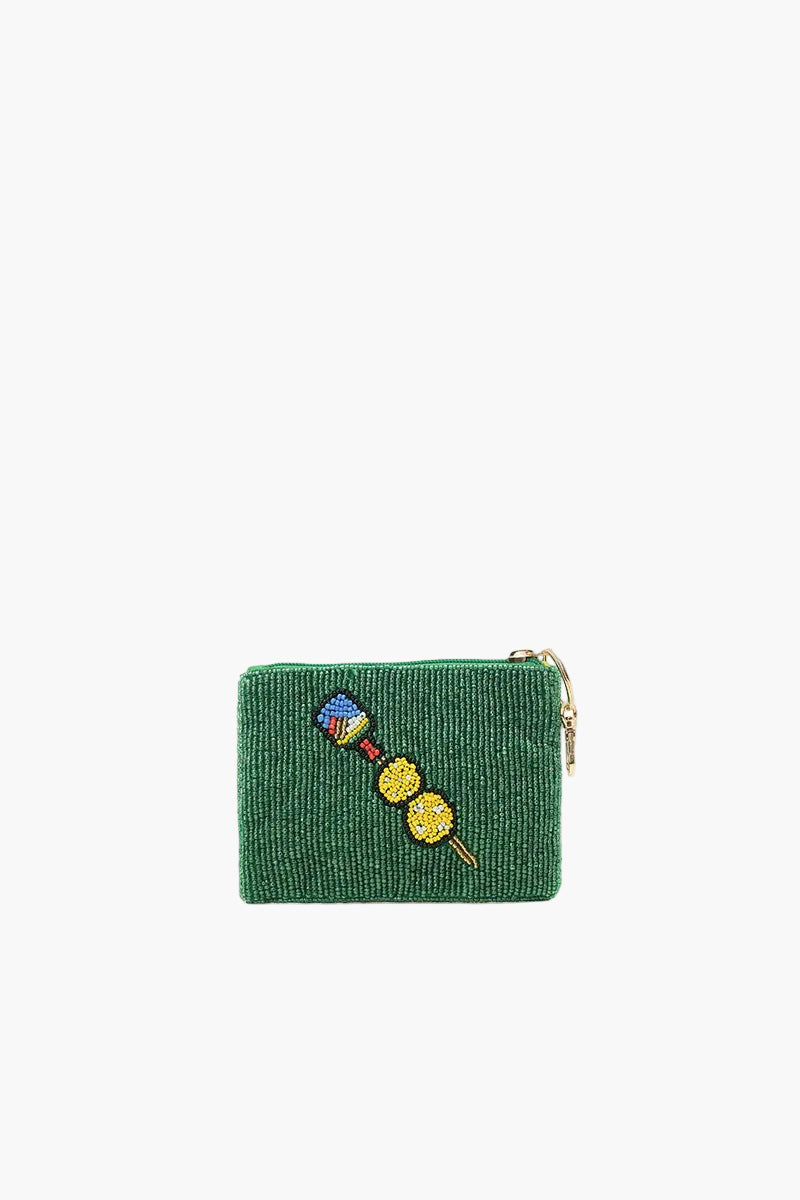 Green textured pouch with colorful brooches on a white background
