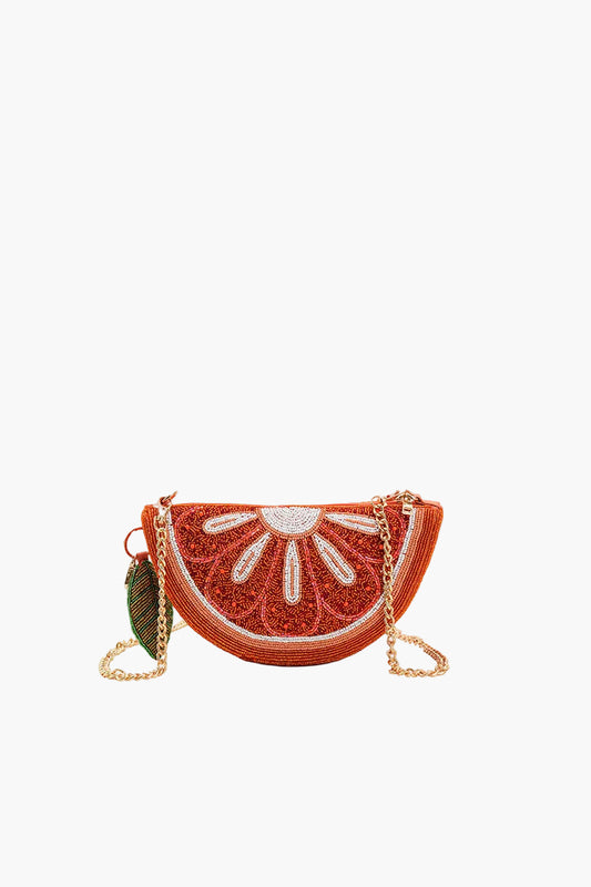 Semicircular handbag designed like a slice of orange with chain strap on a white background