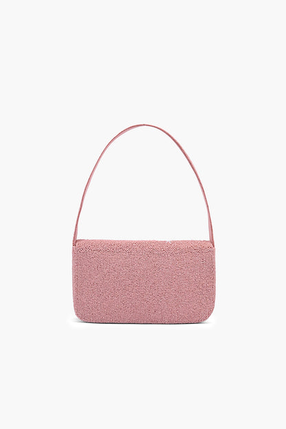 Pink woven handbag on a light pink background