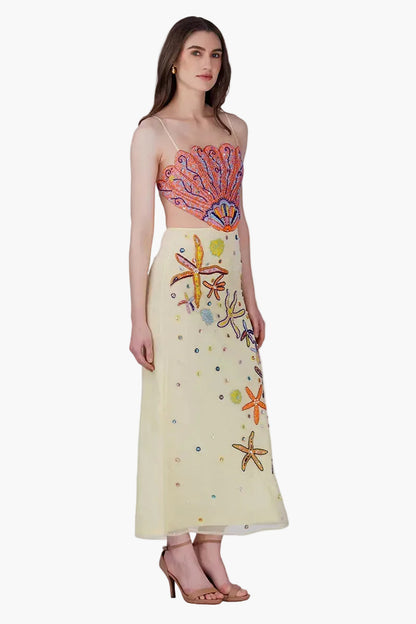 Woman wearing a colorful top and skirt with floral patterns on a white background