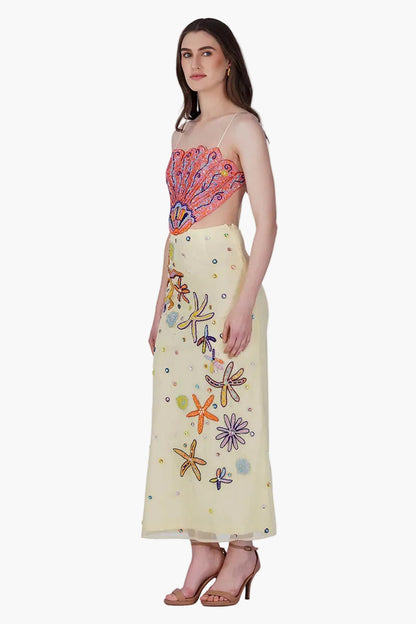 Woman wearing a colorful top and embroidered skirt on a white background