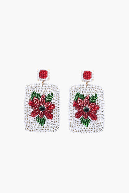 Square beaded earrings with red floral design on a white background